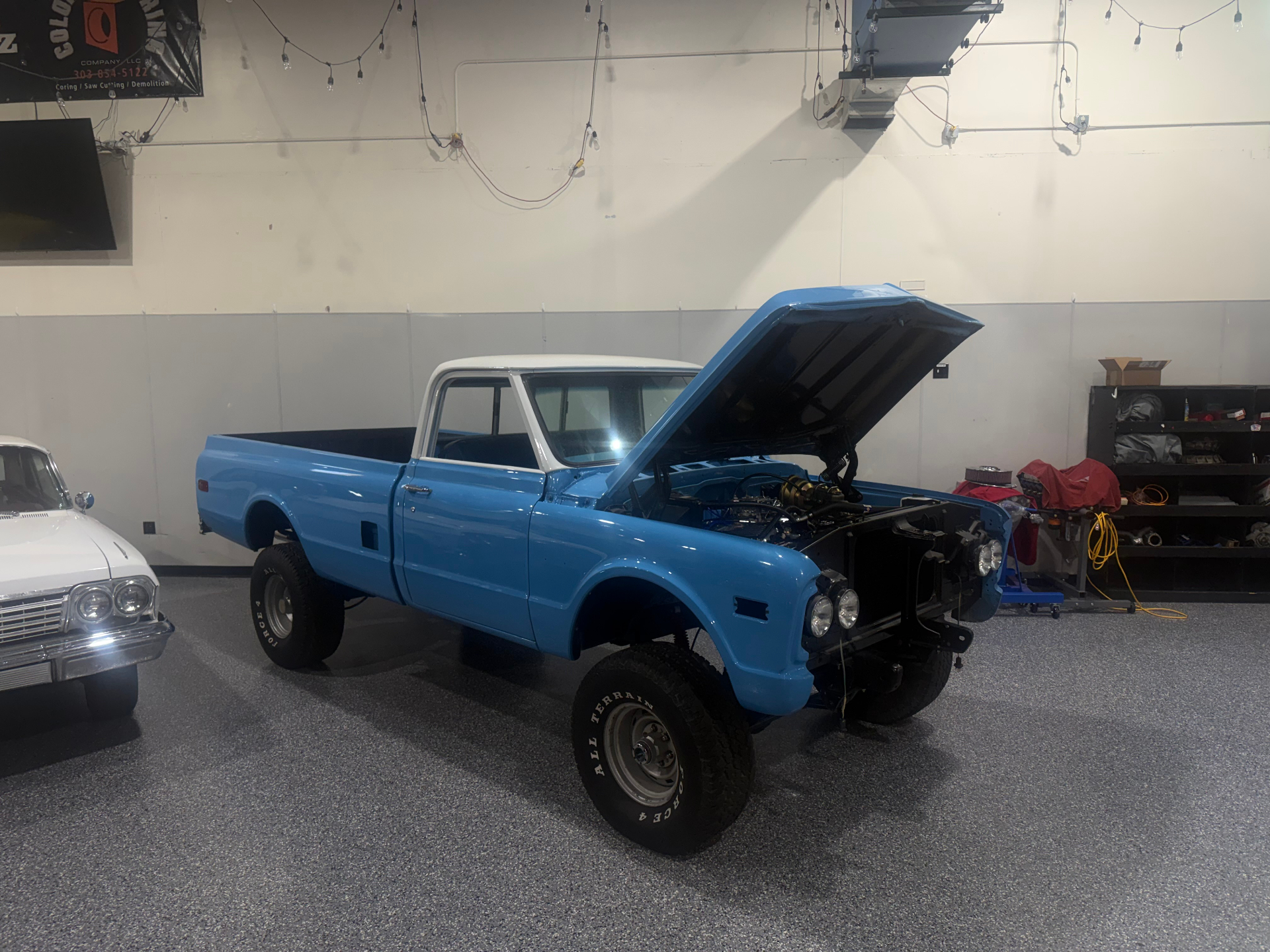 Blue lifted classic pickup truck in the shop